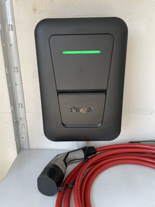 Borne de recharge Hager murale avec câble rouge dans un garage