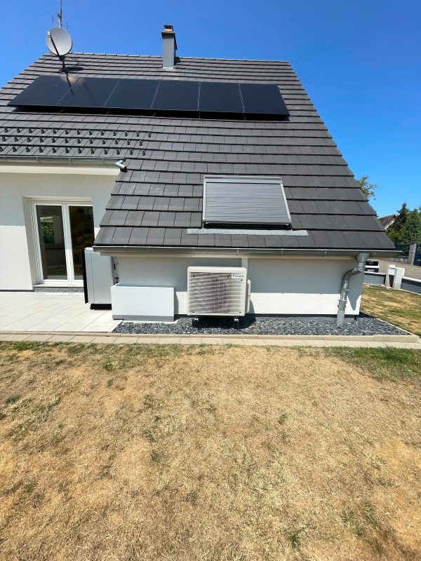 Panneaux photovoltaïques en toiture et groupe extérieur Daikin sur une même maison
