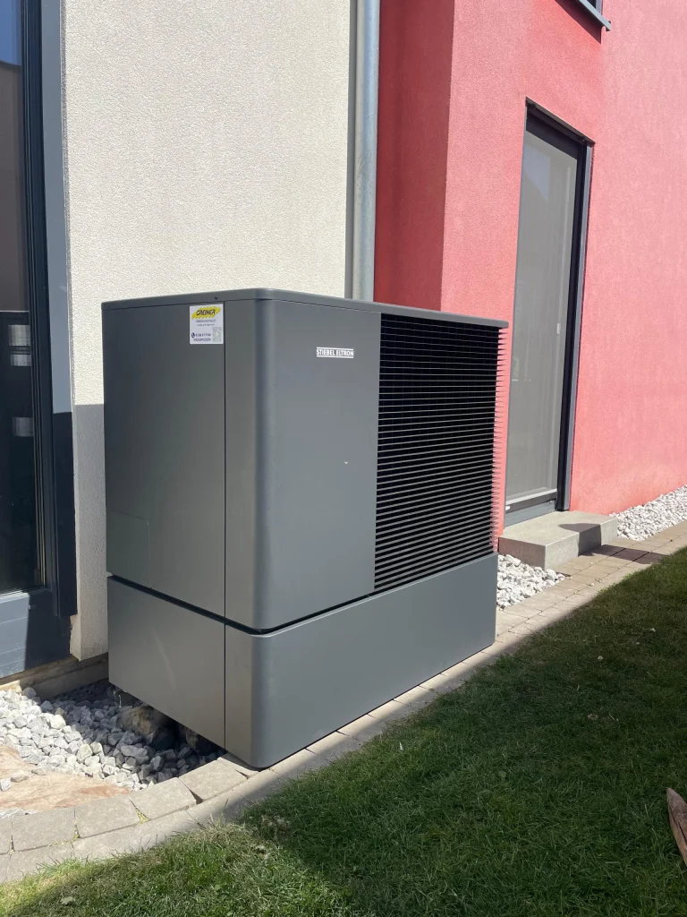 Pompe à chaleur Stiebel Eltron avec l’étiquette GREINER devant une maison